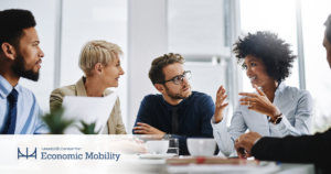 This is an image of two women and two men talking during a business meeting. 