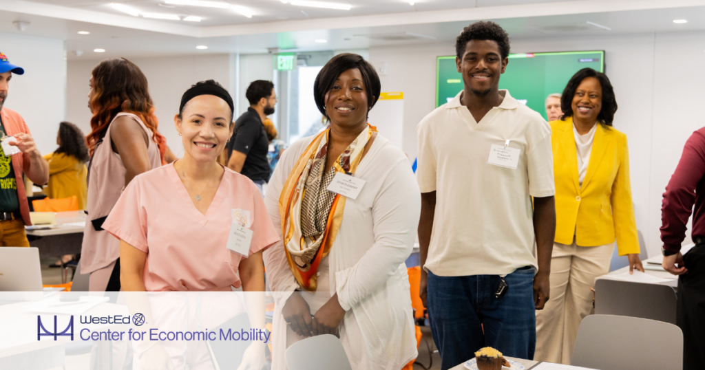 Participants stand together during a community workforce and economic mobility event in a collaborative learning space.
